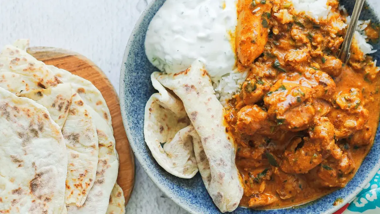 Pyszny butter chicken przepis: kremowy kurczak w sosie pomidorowym z ryżem, jogurtem i chlebkami naan.