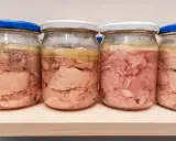 Kilka słoików z domowym mięsem w galarecie, gotowym do spożycia.