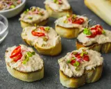 Pyszna pasta z makreli przepis na chrupiących grzankach, udekorowana papryczką i kiełkami. Idealna na przekąskę.