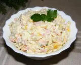 Pyszna sałatka na Wielkanoc z szynką, jajkiem i kukurydzą, udekorowana natką pietruszki.