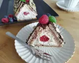 Trójkątny deser z kremem i wiśnią w środku, przypominający chatkę Baby Jagi. Udekorowany owocami i płatkami migdałów.