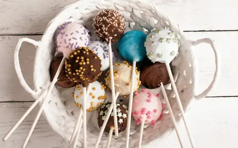 Kolorowe cake pops w koszyku, idealne na przyjęcie. Prosty cake pops przepis, by je zrobić samemu!