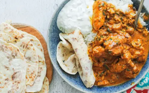 Pyszny butter chicken przepis: kremowy kurczak w sosie pomidorowym z ryżem, jogurtem i chlebkami naan.