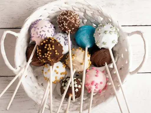 Kolorowe cake pops w koszyku, idealne na przyjęcie. Prosty cake pops przepis, by je zrobić samemu!