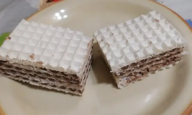 Dwa kwadratowe wafle z kremem czekoladowym, przypominające smakiem wafle z mlekiem w proszku. Idealne na deser.