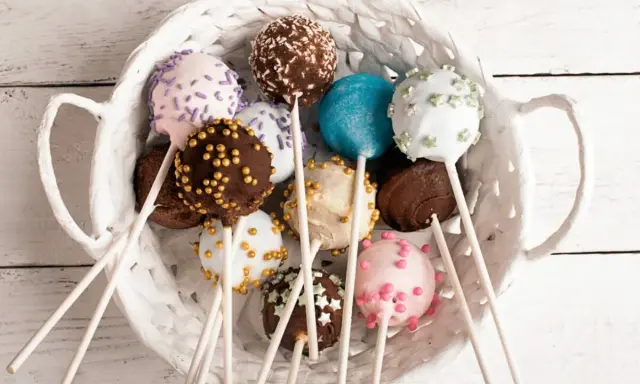 Kolorowe cake pops w koszyku, idealne na przyjęcie. Prosty cake pops przepis, by je zrobić samemu!