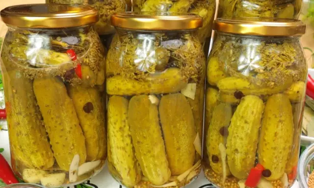 Słoiki z ogórkami kiszonymi, idealne na przepis na ogórki w occie. Widać przyprawy, czosnek i chili.