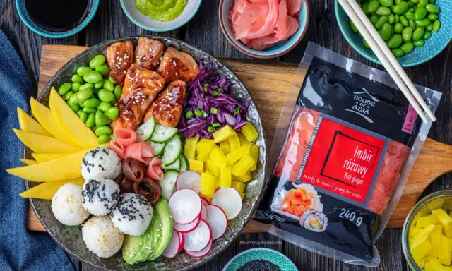 Kolorowy bowl z lososiem, ryżem, mango, awokado, edamame i marynowanym imbirem. Obok opakowanie imbiru różowego.