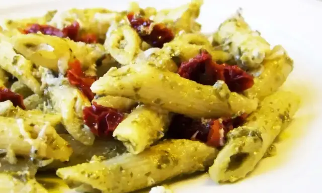 Penne z pesto i kawałkami suszonych pomidorów, posypane parmezanem. Pyszne danie, które zachwyci każdego miłośnika makaronu.