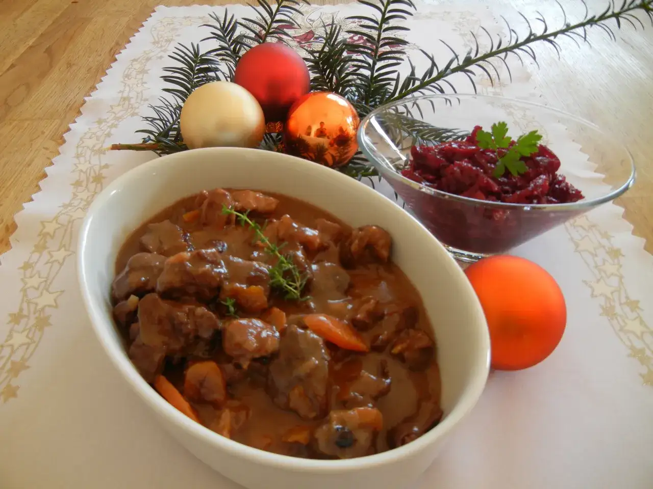 Aromatyczny gulasz z sarny w sosie, podany z żurawiną i świątecznymi ozdobami.