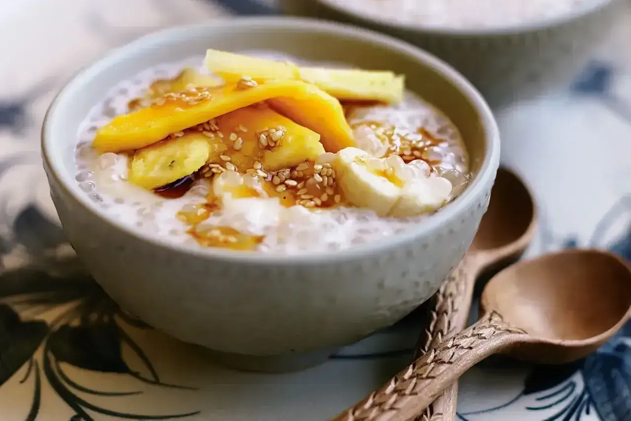 Pyszny deser z tapioki z kawałkami mango i banana, posypany sezamem. Idealny na letnie popołudnie.