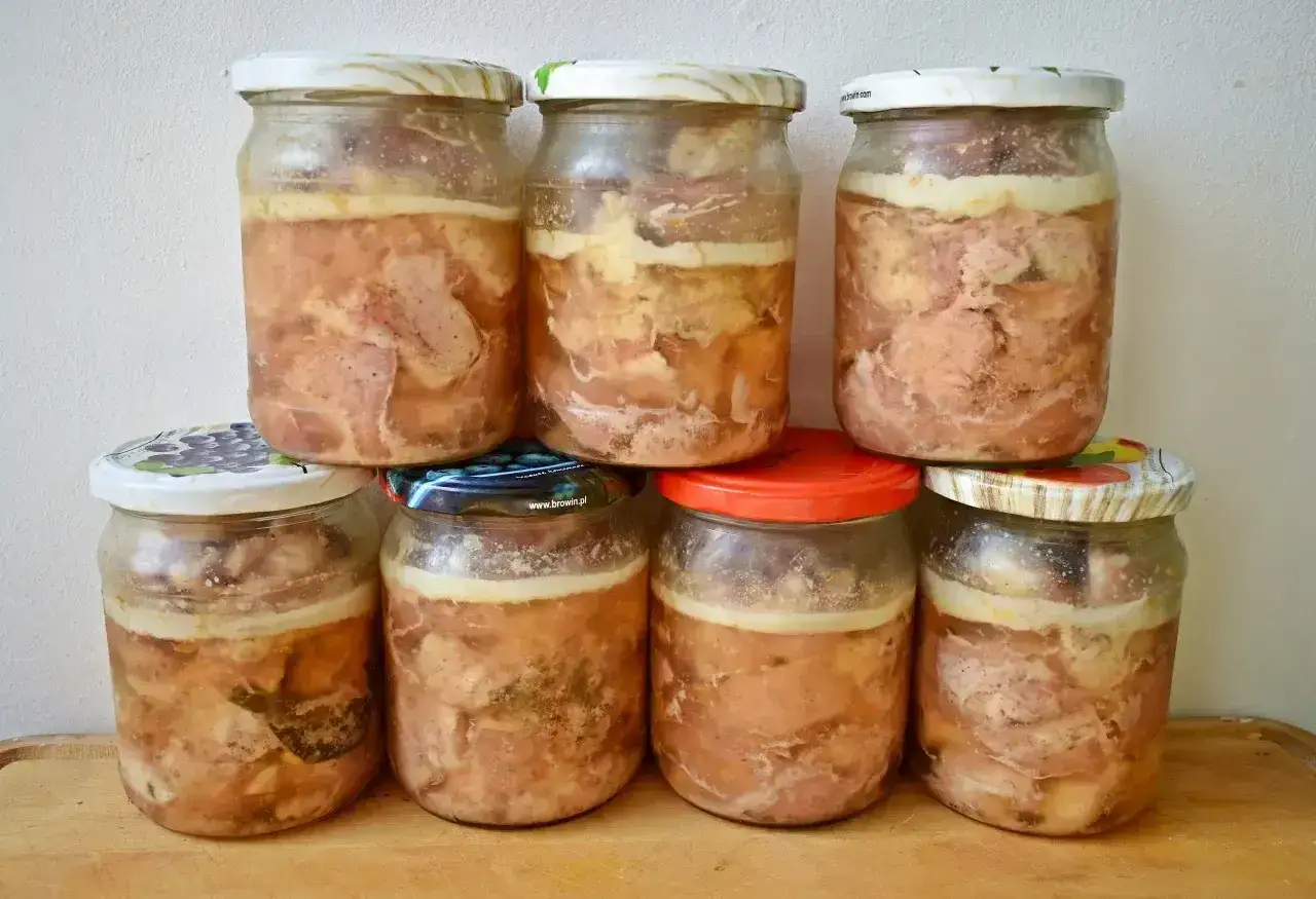 Siedem słoik&oacute;w domowego mięsa w galarecie, przygotowanego na zimę.
