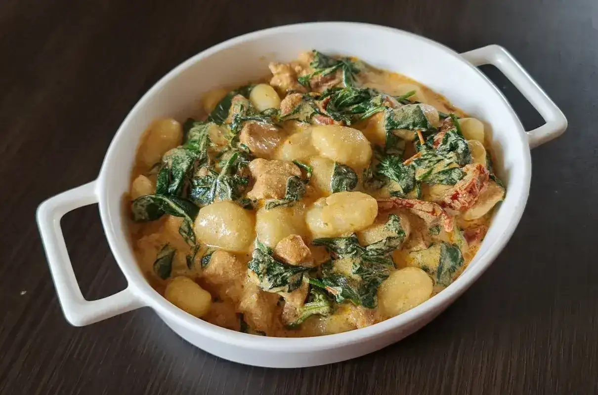 Pyszne gnocchi z kurczakiem w kremowym sosie ze szpinakiem i suszonymi pomidorami.