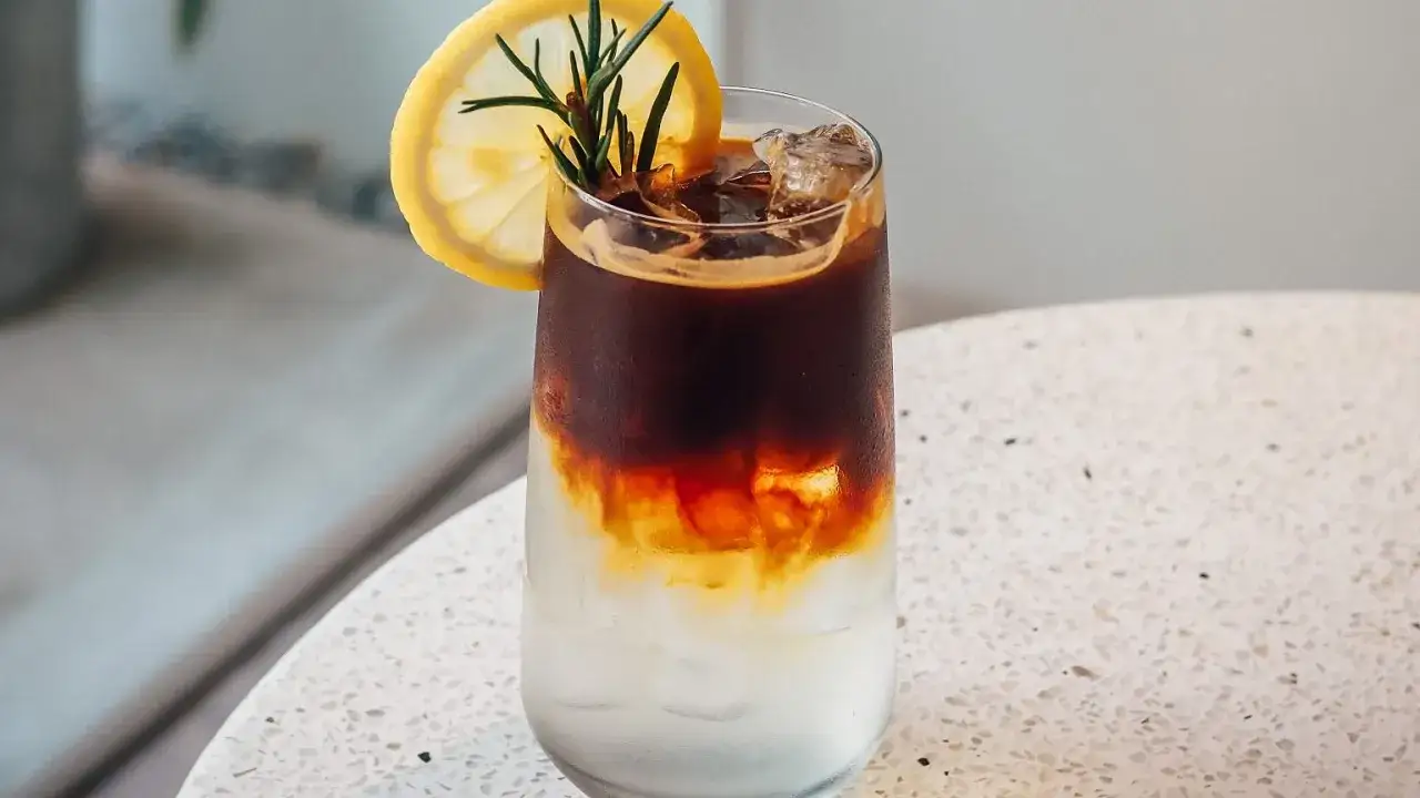 Orzeźwiający tonic espresso z lodem, plasterkiem cytryny i rozmarynem. Idealny przepis na lato.