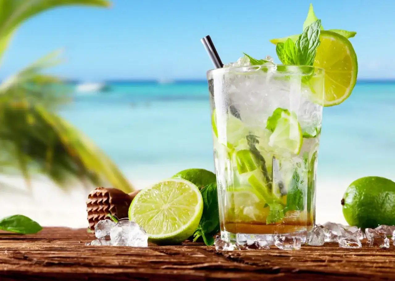 Idealny przepis na mohito: orzeźwiający drink z limonką i miętą na tle plaży.